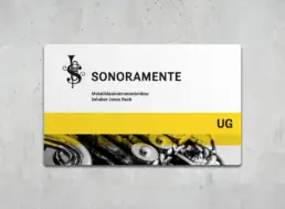 Firmenschild auf grauer Betonwand